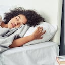 Foto de una mujer joven durmiendo plácidamente en su cama