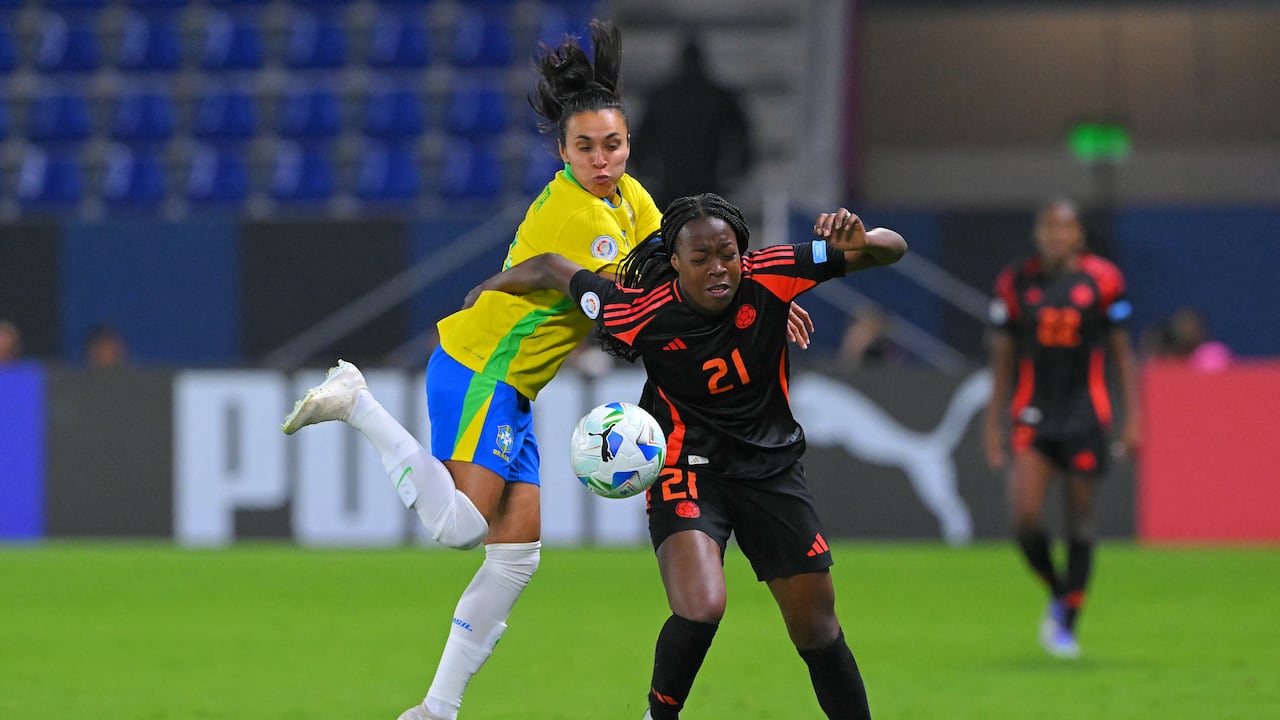 La capitana e histórica jugadora de Brasil, Marta, intenta quitarle el balón a la joven colombiana, Valerin Loboa. (Foto Rodrigo BUENDIA / AFP)