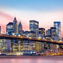 Puente de Brooklyn y el horizonte del Bajo Manhattan bajo una puesta de sol púrpura