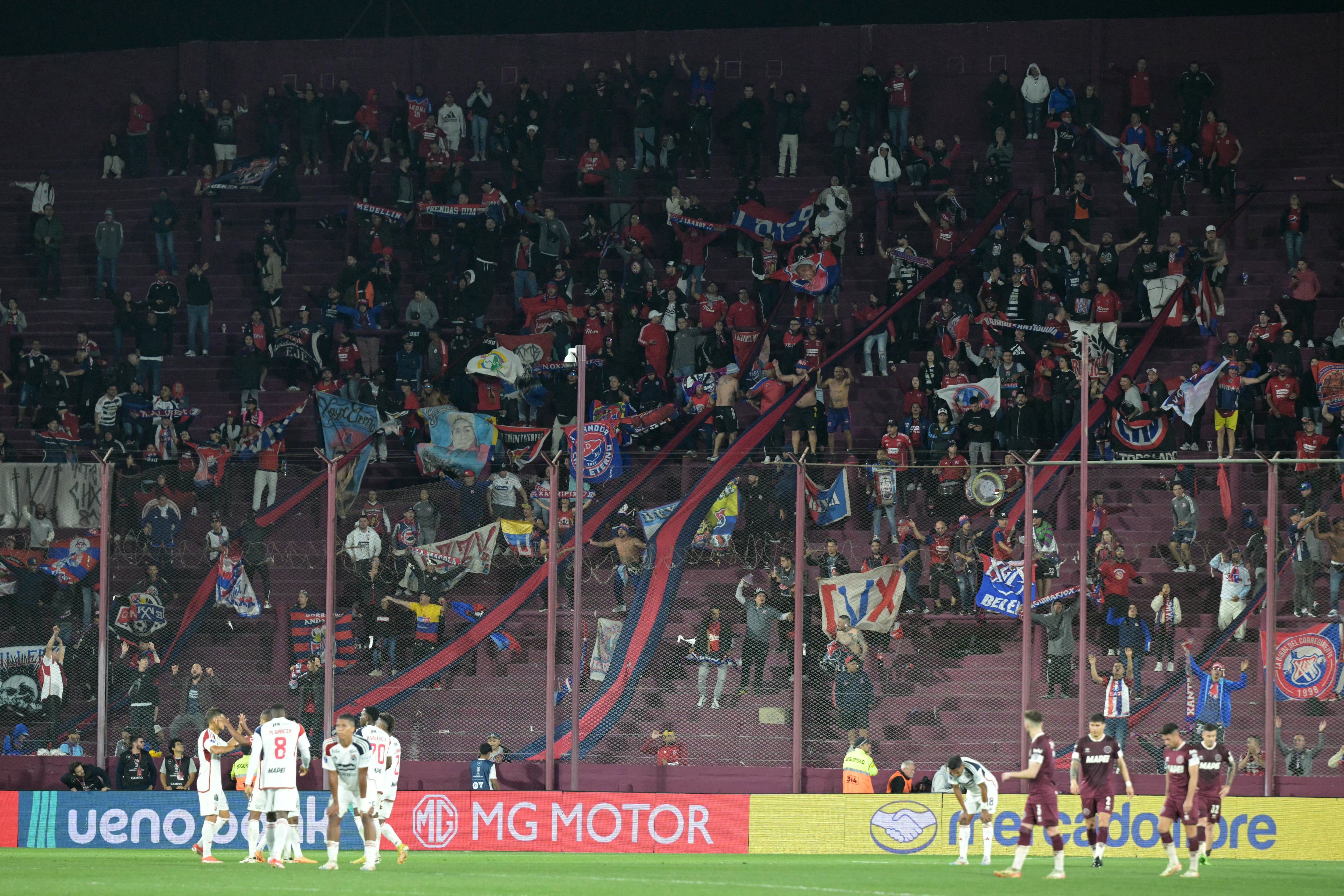 Independiente Medellin fans celebrate the tie at the end of the Copa Sudamericana quarter-final first leg football match between Argentina's Lanus and Colombia's Independiente Medellin at the Ciudad de Lanus stadium in Lanus, Buenos Aires province, Argentina, on September 18, 2024. (Photo by JUAN MABROMATA / AFP)