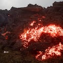 Un hombre empuja un flujo de lava con un palo, mientras brota de las laderas del volcán Pacaya, cerca del pueblo El Patrocinio en San Vicente Pacaya, Guatemala, el jueves 15 de abril de 2021. (Foto AP / Moisés Castillo)