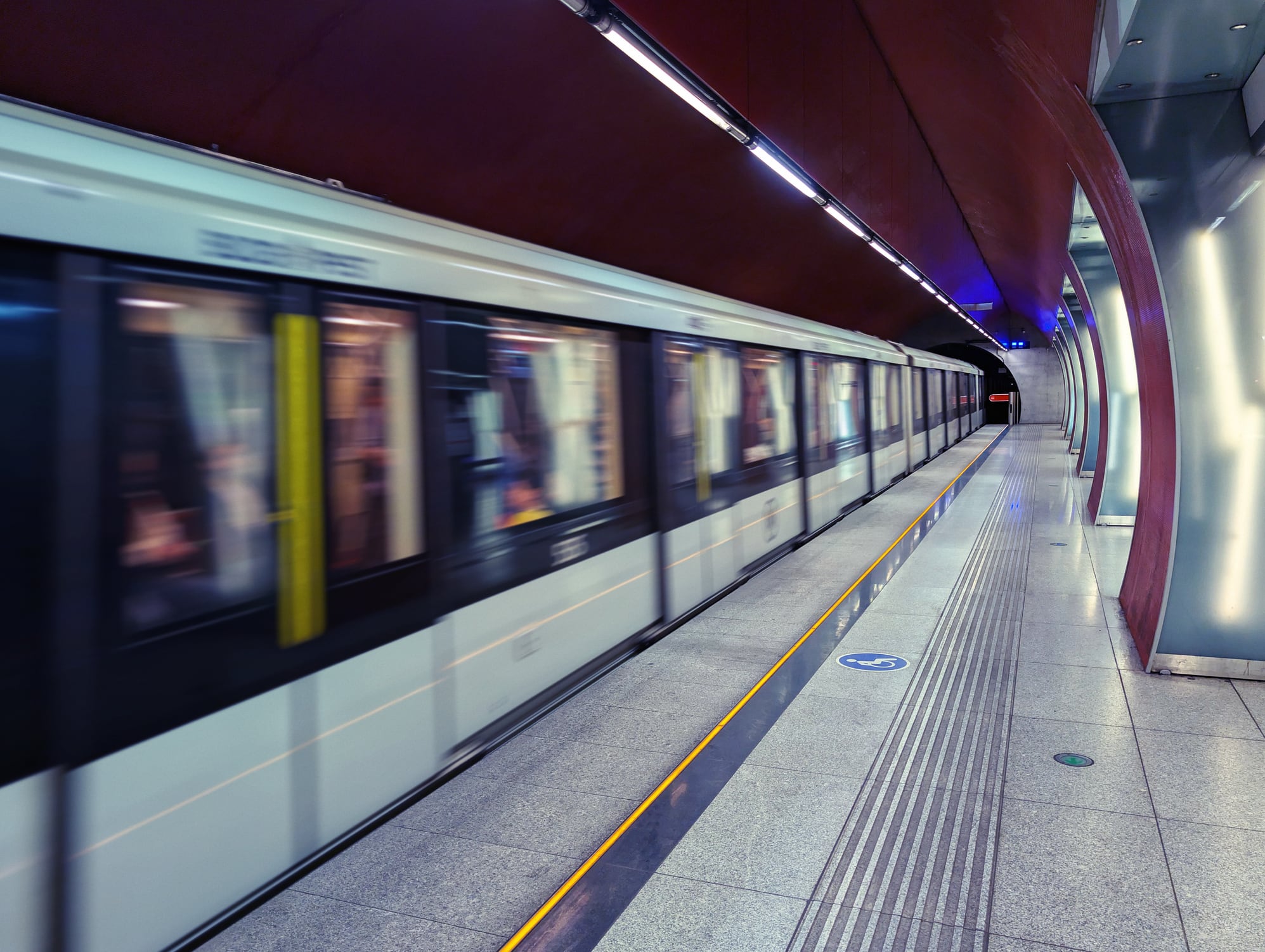 Un elegante tren subterráneo capturado en movimiento borroso avanza a toda velocidad a través de una estación de metro contemporánea, en Budapest (Hungría)