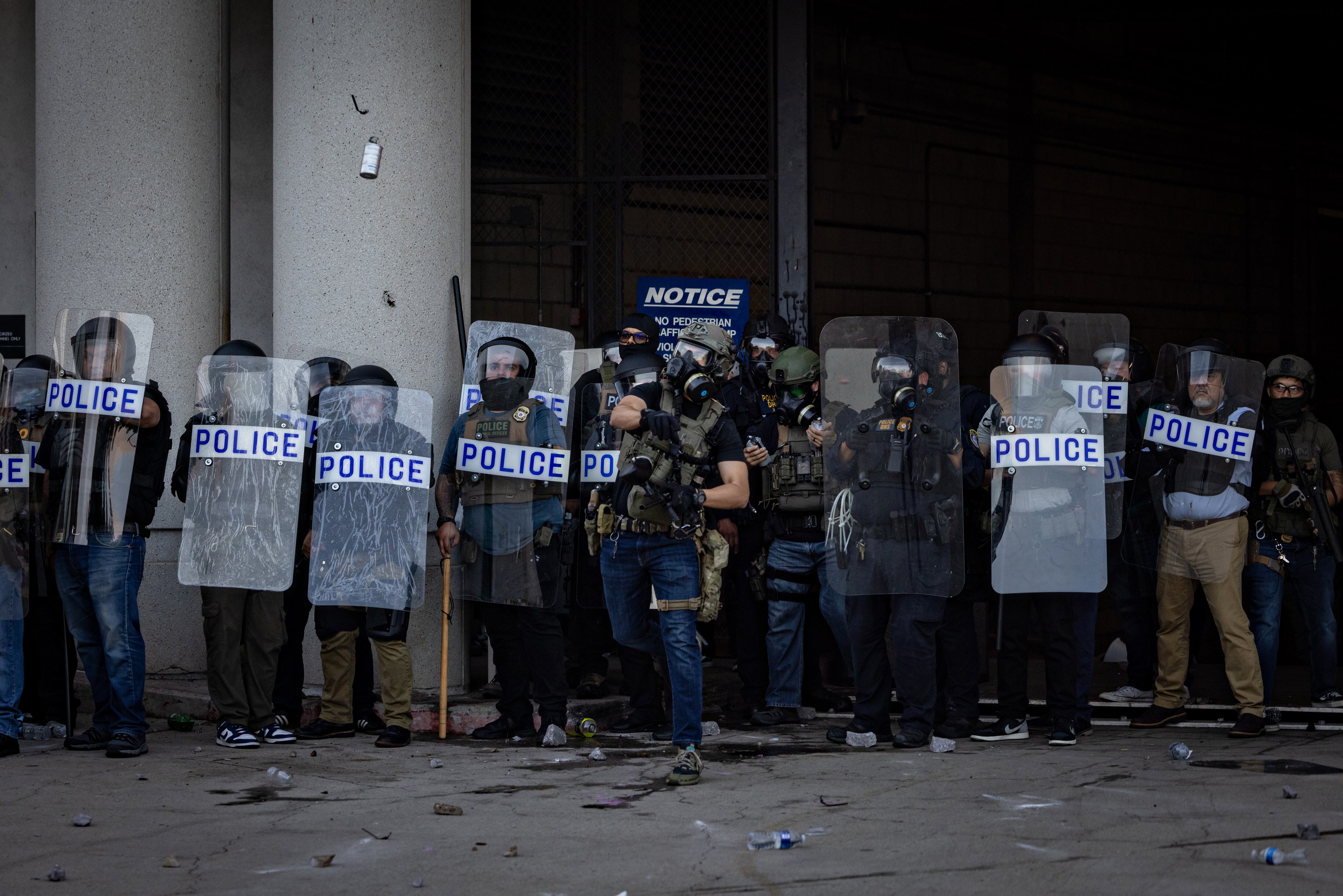 Policías del DHS montan guardia en el Centro de Detención Metropolitano mientras manifestantes se congregan en respuesta a las redadas de ICE en Los Ángeles el viernes 6 de junio de 2025.