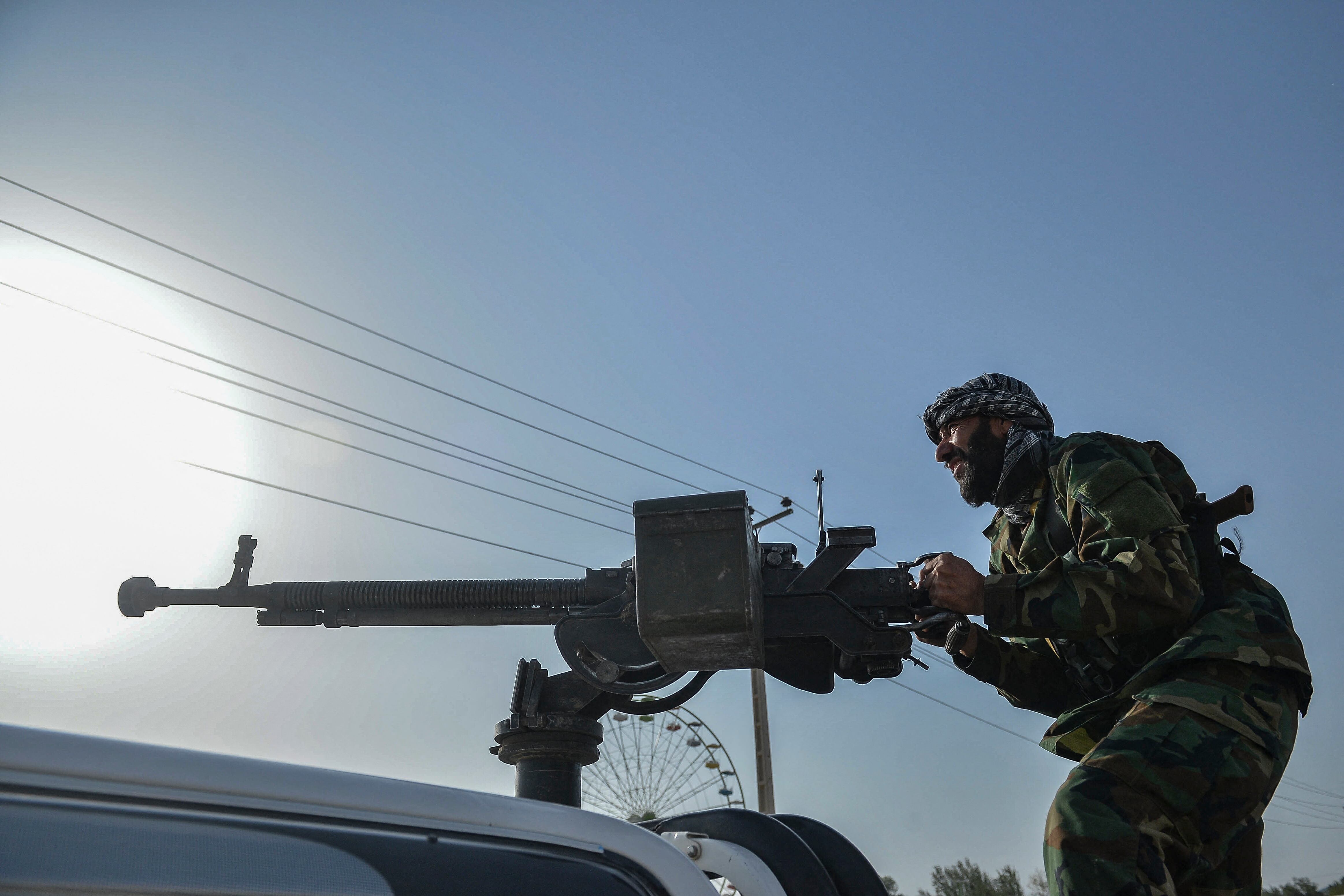 Afghan security personnel and Afghan militia fighting against Taliban, stand guard in Enjil district of Herat province on July 30, 2021. (Photo by Hoshang Hashimi / AFP)