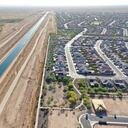 BUCKEYE, ARIZONA - JUNE 08: In an aerial view, a new home is seen under construction (LOWER R) at a housing development near the Central Arizona Project canal (L) running through the Sonoran Desert on June 8, 2023 in Buckeye, Arizona. Buckeye is one of the fastest growing cities in the country and is located on the fringe of the Phoenix metropolitan area. Arizona Governor Katie Hobbs announced last week that that there is a shortage of groundwater for new housing construction which has been previously approved in the Phoenix metropolitan area. Arizona will no longer be able to give developers new permits for home construction in some outlying areas of Maricopa County which rely on groundwater wells. Some developers and affected cities will need to search for alternative sources of water for future development amid a warming climate. (Photo by Mario Tama/Getty Images)