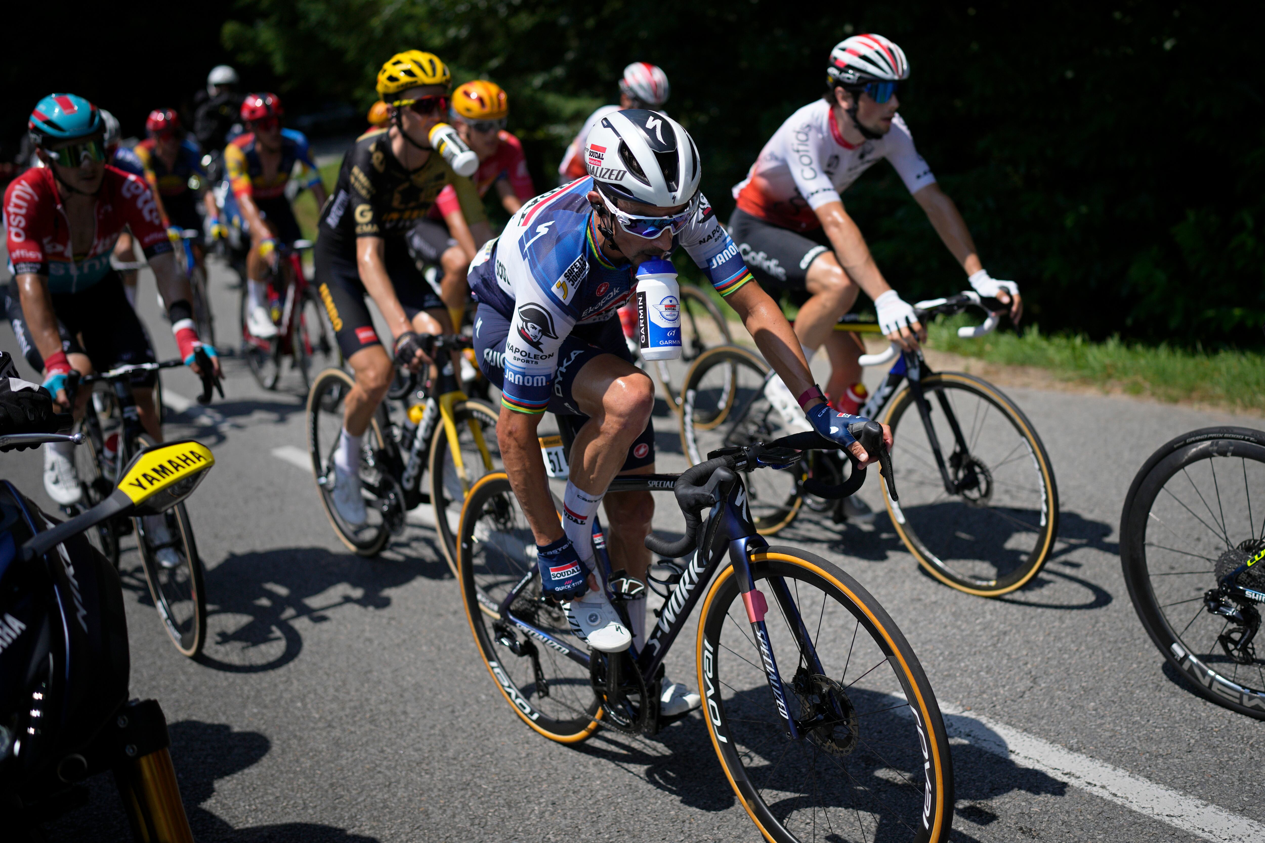 El francés Julian Alaphilippe sostiene una botella con los dientes durante la novena etapa de la carrera ciclista del Tour de Francia de 182,5 kilómetros (113,5 millas) con inicio en Saint-Leonard-de-Noblat y final en Puy de Dome, Francia, el domingo 9 de julio. , 2023. (Foto AP/Daniel Cole)