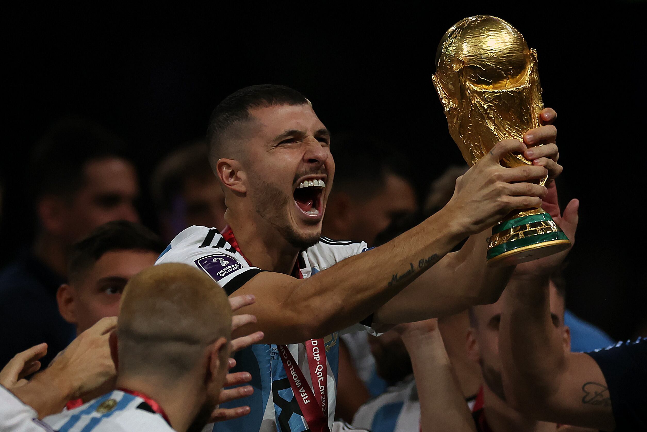 LUSAIL CITY, QATAR - DECEMBER 18: Guido Rodríguez of Argentina holds the World Cup Trophy aloft during the FIFA World Cup Qatar 2022 Final match between Argentina and France at Lusail Stadium on December 18, 2022 in Lusail City, Qatar. (Photo by Getty Images/Ian MacNicol)
