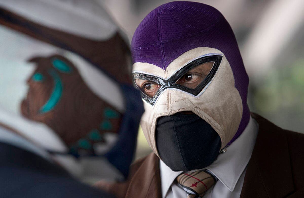 El Fantasma, presidente de la Comisión de Lucha Libre de la Ciudad de México conversa con su compañero luchador Canek, antes de entregar paquetes de comida donados por un supermercado local a otros luchadores que atraviesan tiempos difíciles en la Ciudad de México. Los luchadores no han podido trabajar durante meses debido a la pandemia de covid-19 que ha cerrado sus escenarios. Foto: Marco Ugarte / AP