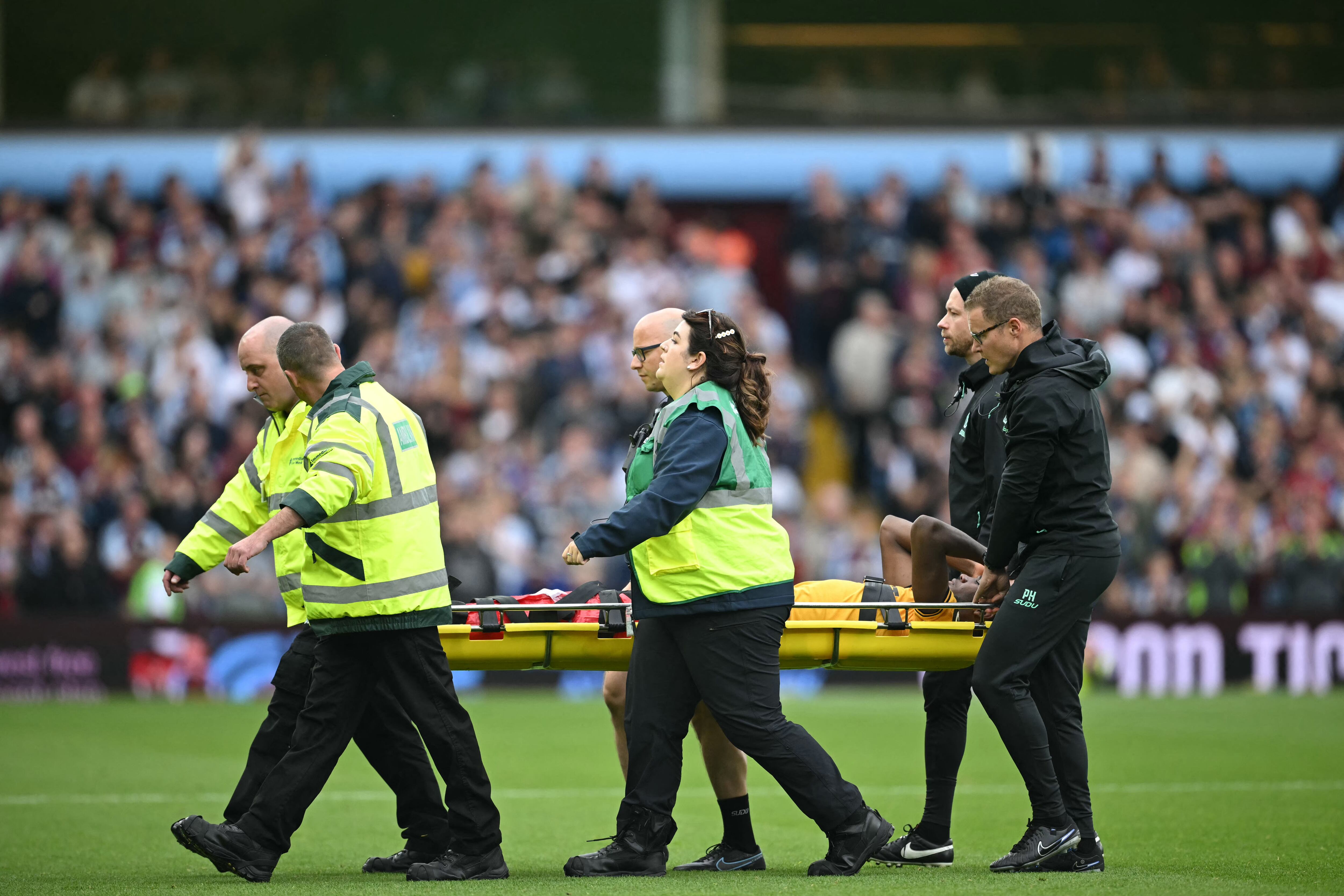Wolverhampton Wanderers' Colombian defender #14 Yerson Mosquera is brought off on a stretcher after being fouled  during the English Premier League football match between Aston Villa and Wolverhampton Wanderers at Villa Park in Birmingham, central England on September 21, 2024. (Photo by JUSTIN TALLIS / AFP) / RESTRICTED TO EDITORIAL USE. No use with unauthorized audio, video, data, fixture lists, club/league logos or 'live' services. Online in-match use limited to 120 images. An additional 40 images may be used in extra time. No video emulation. Social media in-match use limited to 120 images. An additional 40 images may be used in extra time. No use in betting publications, games or single club/league/player publications. /
