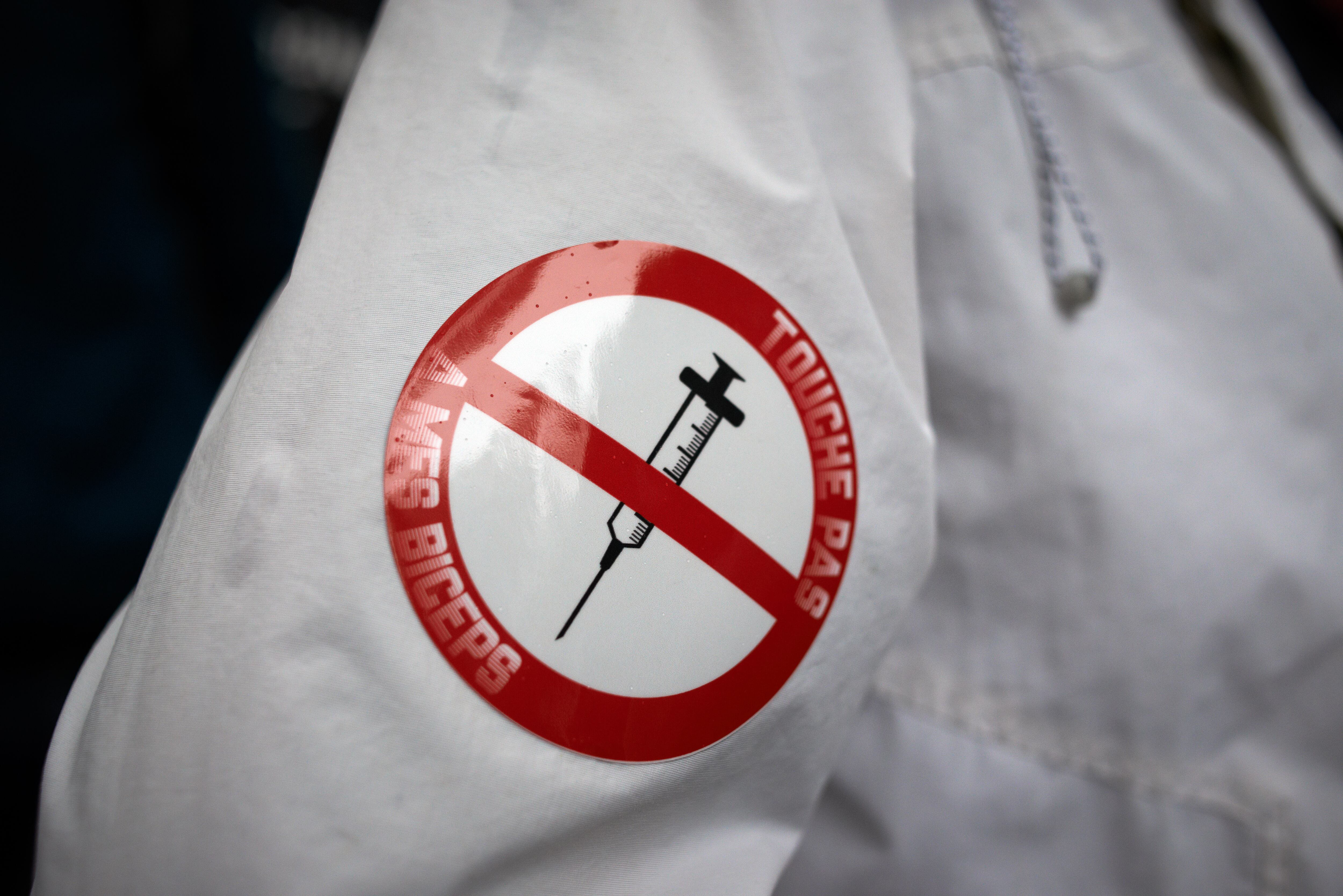 Una pegatina en un manifestante dice "no toques mis bíceps". Miles de manifestantes salieron a las calles en Toulouse contra la vacunación casi obligatoria y contra el pase de salud después del discurso de Macron el 12 de julio, como en más de 150 ciudades de Francia. Macron anunció que el pase de salud será obligatorio para ir a lugares públicos como cafés, teatros, salas de conciertos, cines, centros comerciales, transporte público e incluso hospitales a menos que sea una situación crítica, etc. El retraso entre el primer pinchazo y la obtención del pase de salud serán cinco semanas. Pero la prohibición de espacios públicos para personas no vacunadas comenzará el 9 de agosto luego de un control por parte del Consejo Constitucional. Algunos dicen que son ciudadanos del apartheid y de segunda clase. La protesta fue nuevamente prohibida por el Prefet. La policía antidisturbios utilizó gases lacrimógenos para romper la protesta al final y arrestó a personas. Toulouse. Francia. 31 de julio de 2021 (Foto de Alain Pitton / NurPhoto a través de Getty Images)