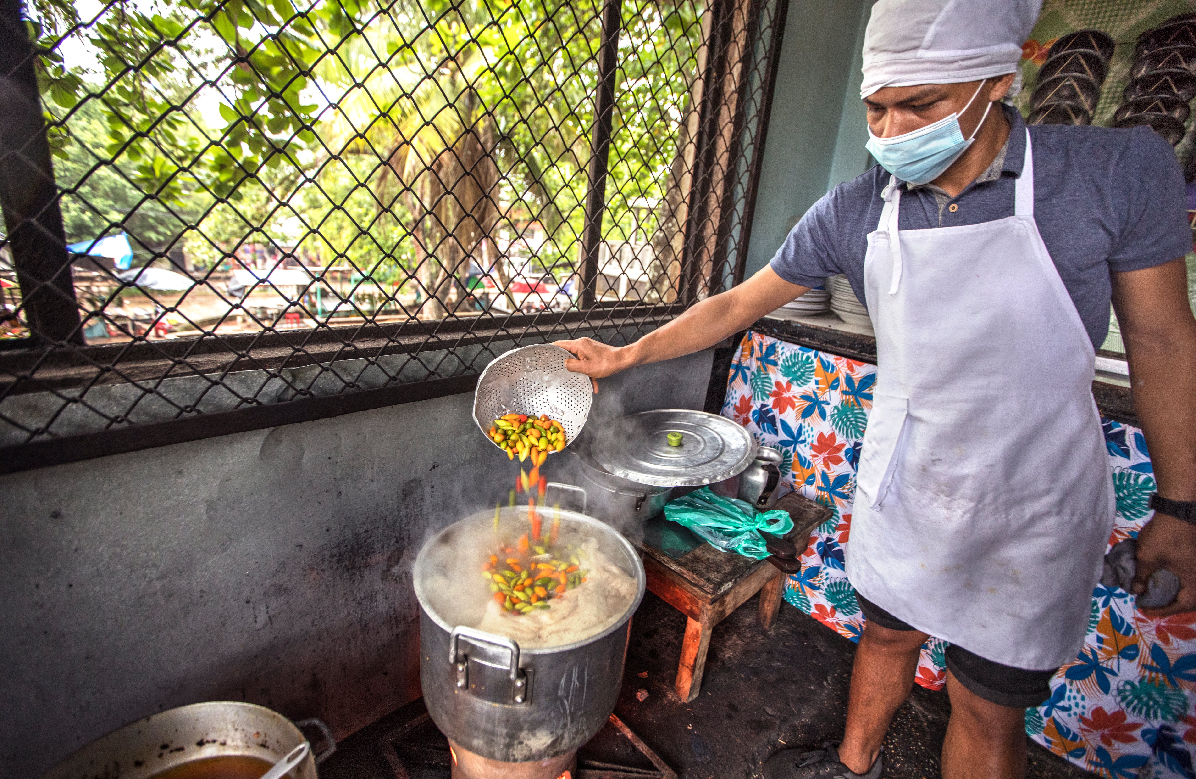 Para preparar el ajicero se debe calentar agua con sal; al hervir, se agrega el pescado. Cuando este se cocina, se añade el ají y se deja al fuego durante 15 minutos más. Se sirve acompañado de mañoco, casabe o patacón. El ajicero puede ser preparado con bocón,  palometa, cachama, mojarra y bagre, que Ligia busca diariamente en la plaza de mercado del Paujil. “Salgo a las cuatro de la mañana y a las cuatro y media estamos comprando 20 sartas de pescado”, comenta. A las las 7:30 de la mañana, los fogones están al máximo para cumplirle a los primeros comensales. Foto: Juan Carlos Sierra