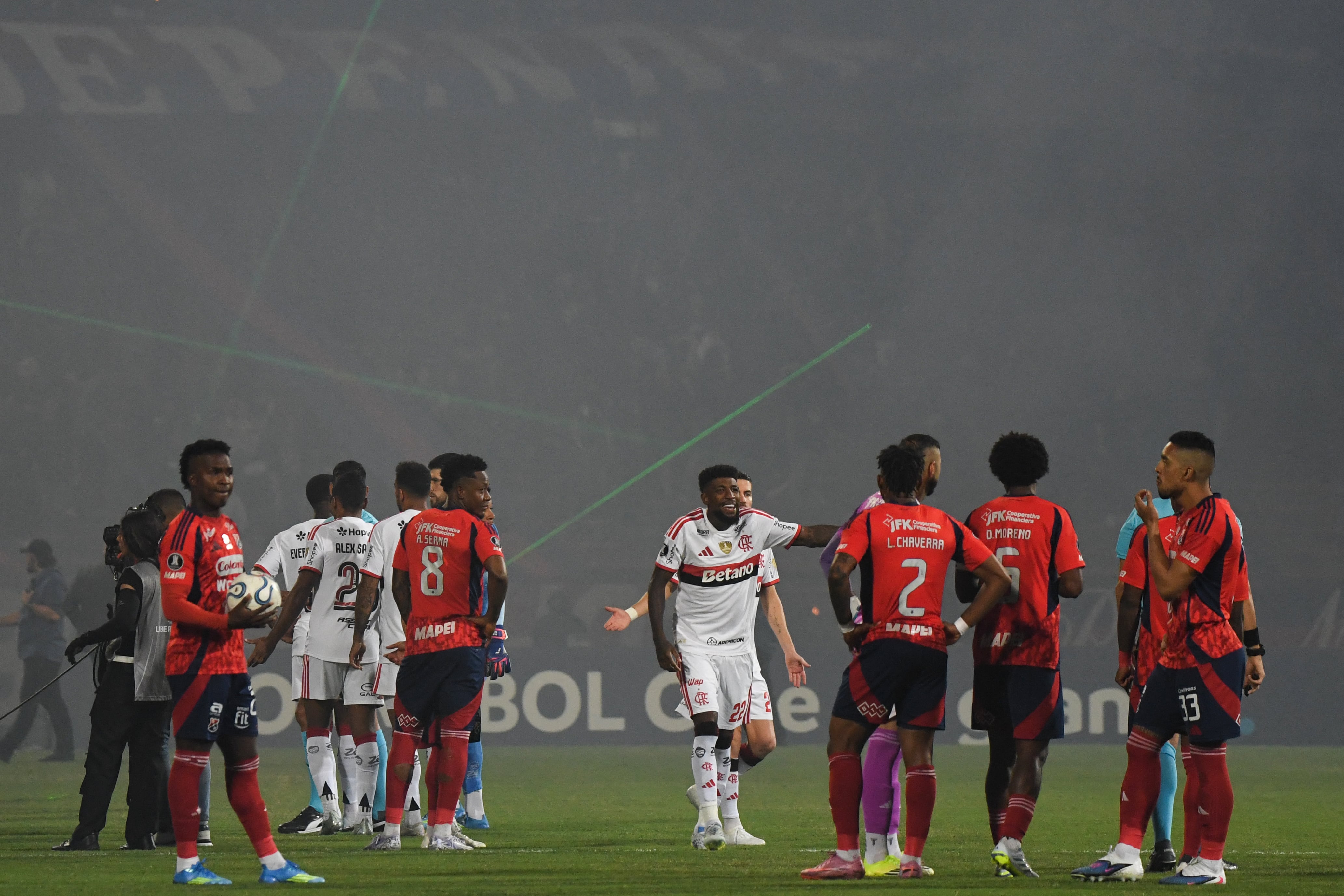 Players from both teams wait for the start of the game after it was delayed during the Copa Libertadores group stage football match between Colombia's Independiente Medellin and Brazil's Flamengo at the Atanasio Girardot stadium in Medellin, Antioquia department, Colombia on May 7, 2026. (Photo by Jaime SALDARRIAGA / AFP)