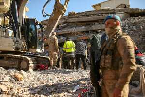 Los equipos de rescate se paran en un edificio derrumbado en Adiyaman, en el sur de Turquía, el lunes 13 de febrero de 2023. Una semana después de que los terremotos mataran a decenas de miles en Siria y Turquía, el dolor y la incredulidad se están convirtiendo en ira. (AP Photo/Emrah Gurel)