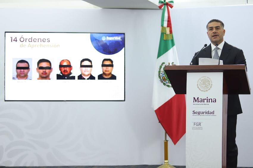 Autoridades mexicanas en conferencia de prensa con bandera nacional al fondo