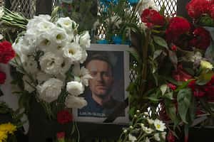 Una fotografía de Alexei Navalny y flores colocadas en una valla que custodia la embajada rusa en Buenos Aires, Argentina, el viernes 16 de febrero de 2024. Navalny, quien hizo una cruzada contra la corrupción oficial y organizó protestas masivas contra el Kremlin como el enemigo más feroz del presidente Vladimir Putin.