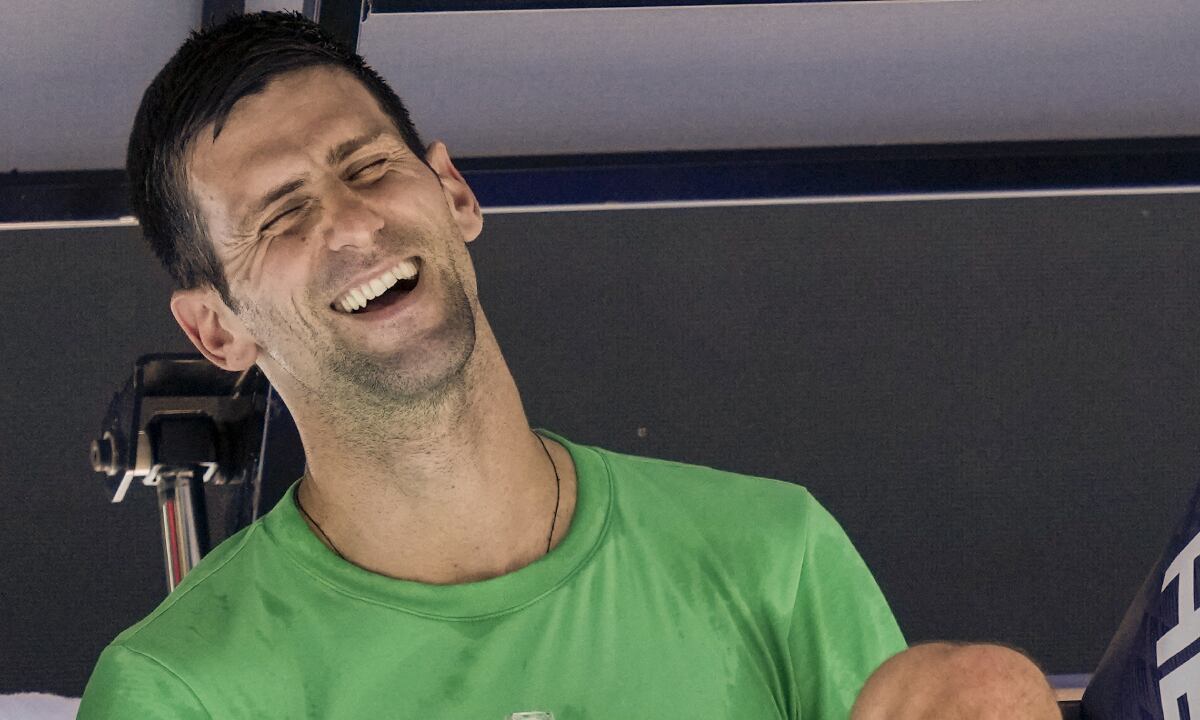 Defending men's champion Serbia's Novak Djokovic laughs as he rests during a practice session on Margaret Court Arena ahead of the Australian Open tennis championship in Melbourne, Australia, Thursday, Jan. 13, 2022. AP /Mark Baker)