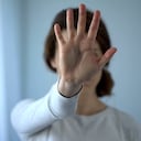 Mujer asustada agotada que muestra la señal de pare, derechos femeninos, asalto en la familia