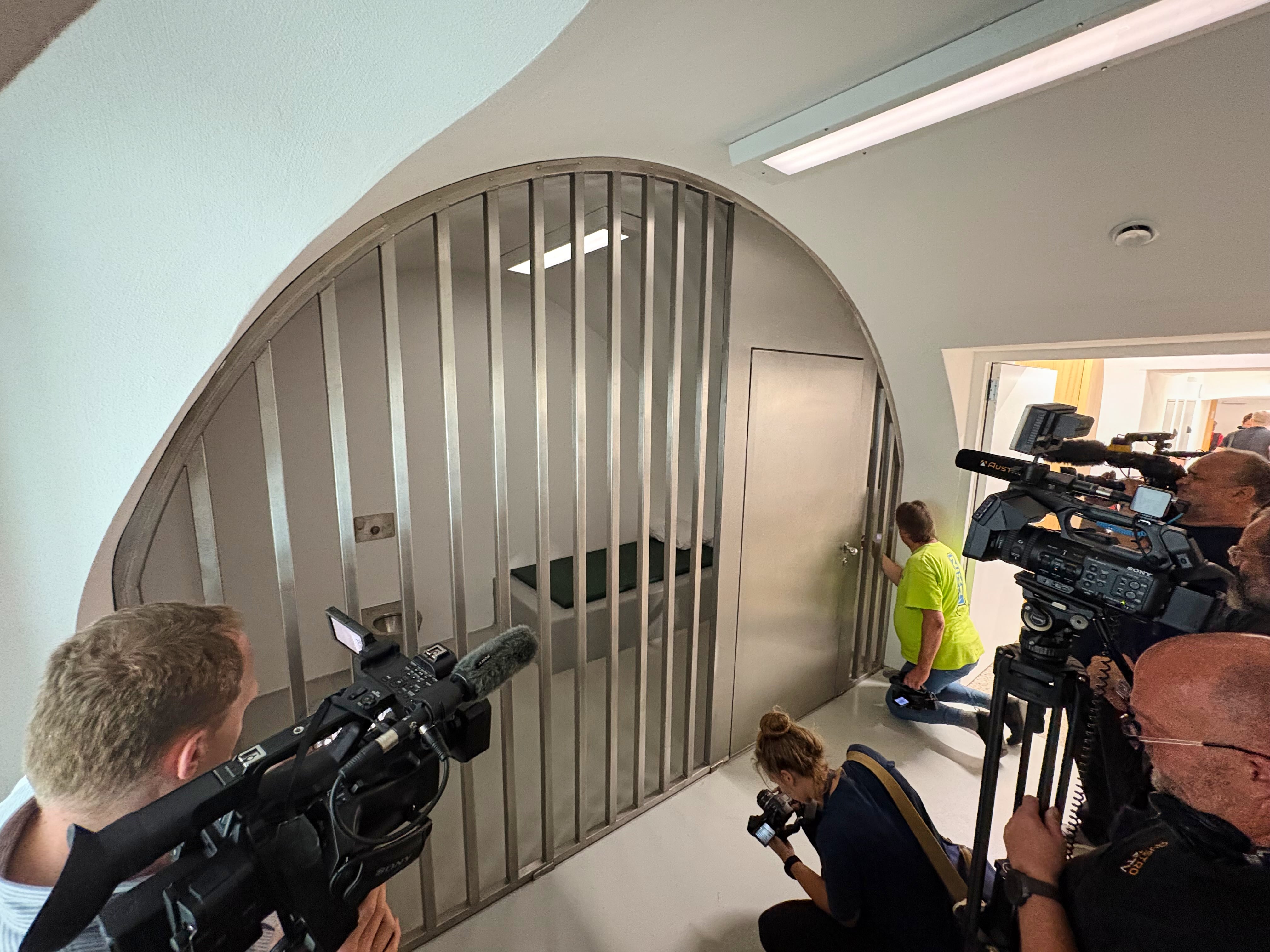 Representantes de los medios de comunicación fotografían una celda en una nueva comisaría de policía ubicada en la casa natal de Adolf Hitler en Braunau am Inn, Austria, el miércoles 22 de julio de 2026. (Foto AP/Matthias Schrader)