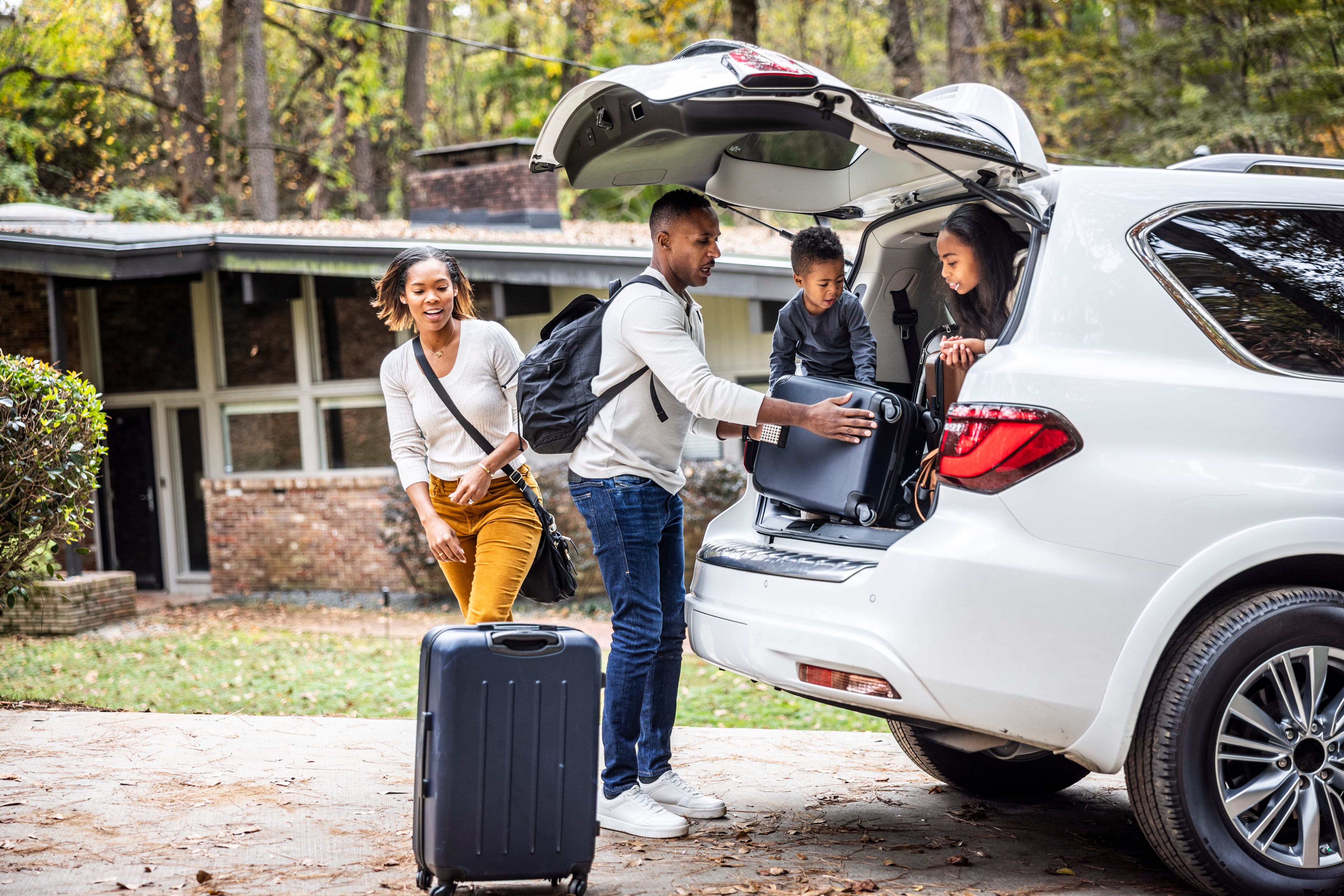 Familia cargando maletas en el coche para vacaciones