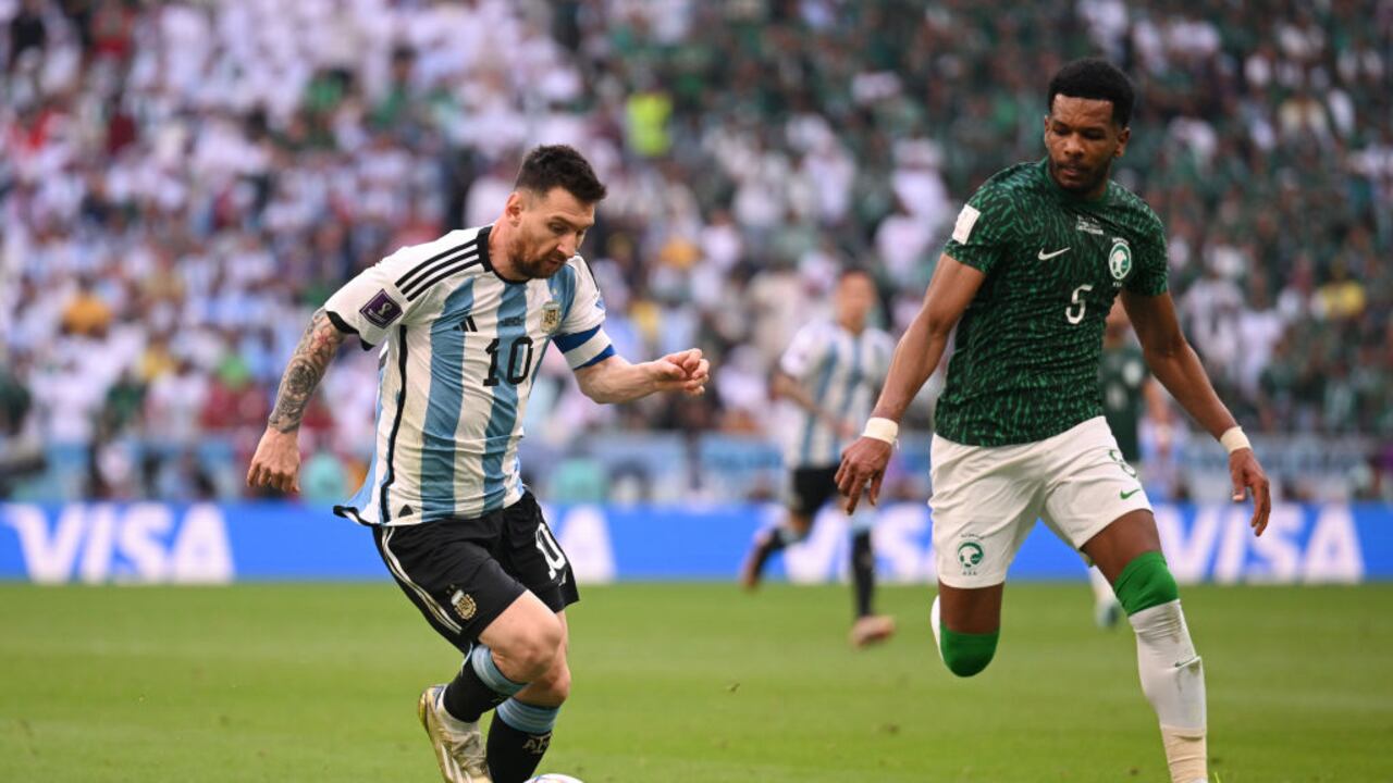 LUSAIL CITY, QATAR - NOVEMBER 22: Lionel Messi of Argentina is challenged by Ali Al-Bulayhi of Saudi Arabia during the FIFA World Cup Qatar 2022 Group C match between Argentina and Saudi Arabia at Lusail Stadium on November 22, 2022 in Lusail City, Qatar. (Photo by Matthias Hangst/Getty Images)