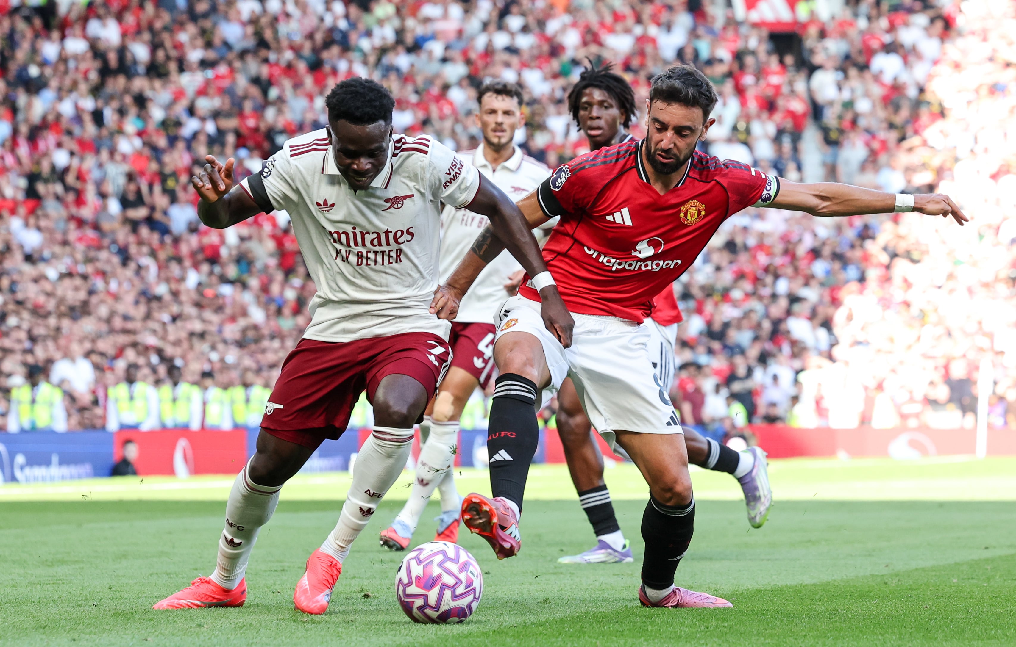 MANCHESTER, ENGLAND - AUGUST 17: Arsenal's Bukayo Saka battles with Manchester United's Bruno Fernandes during the Premier League match between Manchester United and Arsenal at Old Trafford on August 17, 2025 in Manchester, England. (Photo by Alex Dodd - CameraSport via Getty Images)