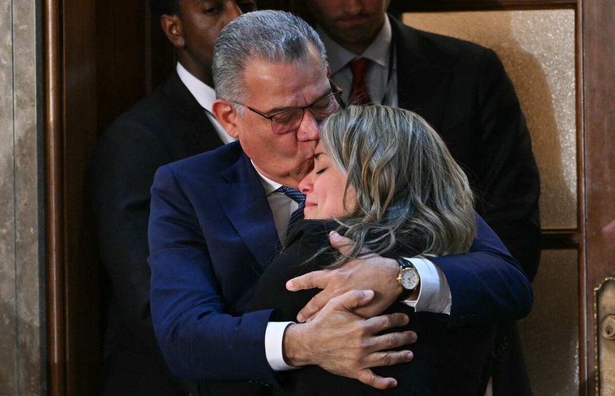 El ex candidato presidencial venezolano y preso político recientemente liberado, Enrique Márquez, abraza a un familiar mientras es reconocido por el presidente estadounidense Donald Trump