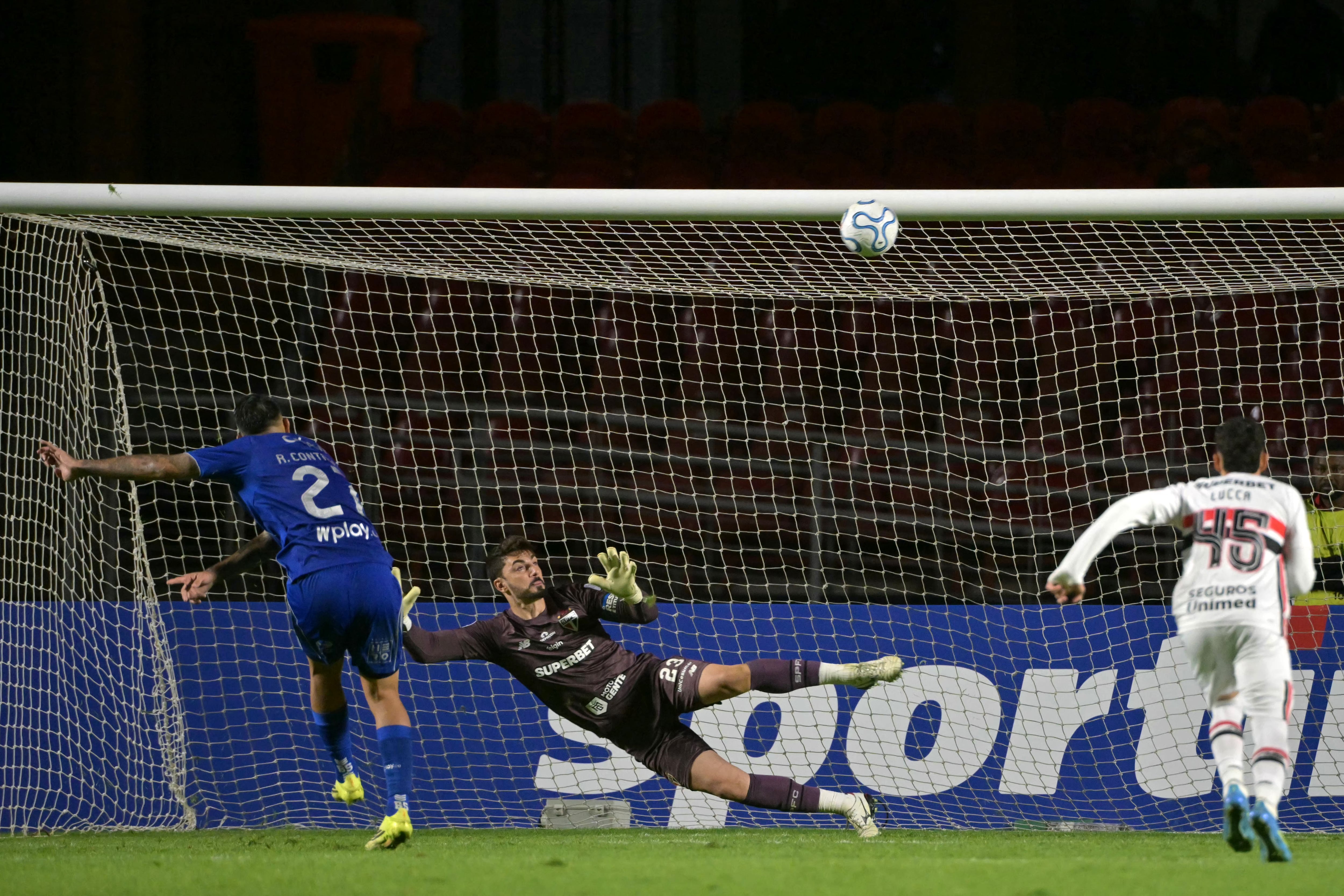 El delantero argentino #27 de Millonarios, Rodrigo Contreras, falla un tiro penal contra el portero #23 de Sao Paulo, Rafael, durante el partido de fútbol de la fase de grupos de la Copa Sudamericana entre Sao Paulo de Brasil y Millonarios de Colombia en el estadio Morumbi en Sao Paulo, Brasil, el 19 de mayo de 2026. (Foto de NELSON ALMEIDA / AFP)