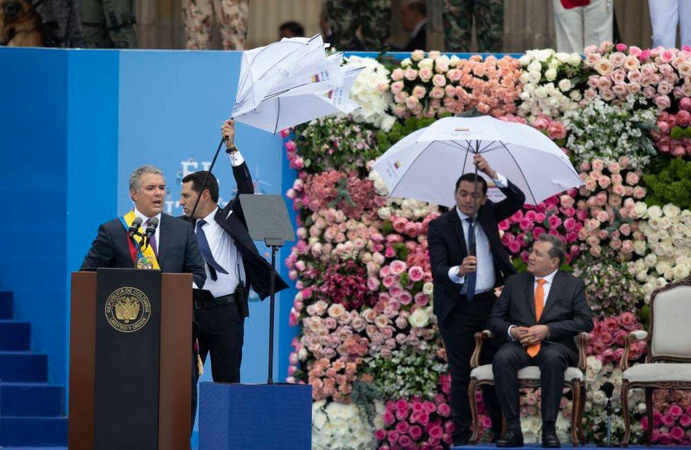 La lluvia, el frío y un ventarrón que parecía apocalíptico marcaron la ceremonia de transmisión de mando en la plaza de Bolívar, al punto en que la sombrilla que protegía a Duque de la lluvia se dañó. Las banderas de Colombia que se habían desplegado en las columnas del Capitolio, el viento las hizo sonar como truenos y las fue derribando una a una. Foto: Esteban Vega / SEMANA