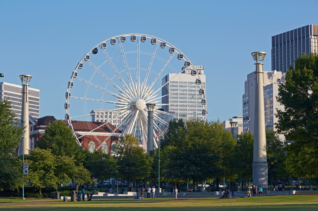 Paisaje urbano de la noria 'Skyview' y rascacielos del centro de Atlanta desde el 'Parque Olímpico Centenario' al atardecer.
