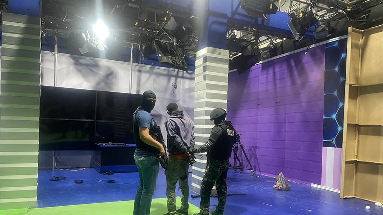 Agentes de policía arrestan a uno de los pistoleros no identificados que irrumpieron en un estudio de la televisión estatal TC en vivo, en Guayaquil, Ecuador, el 9 de enero de 2024, un día después de que el presidente ecuatoriano Daniel Noboa declarara el estado de emergencia tras la fuga de prisión de un peligroso jefe narco. Se escucharon disparos en la televisión en vivo en un Ecuador devastado por la violencia cuando hombres armados con rifles y granadas irrumpieron en el estudio poco después de que gánsteres prometieran una "guerra" contra los planes del presidente de recuperar el control de manos de los "narcoterroristas". (Foto de AFP)