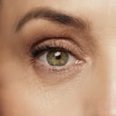 Primer plano del ojo femenino envejecido con piel arrugada