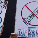 Una mujer sostiene un cartel durante una manifestación contra la vacunación obligatoria COVID-19 para niños en San José, el 5 de enero de 2022. (Photo by Ezequiel BECERRA / AFP)