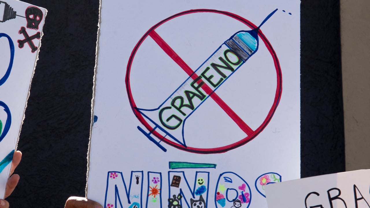 Una mujer sostiene un cartel durante una manifestación contra la vacunación obligatoria COVID-19 para niños, el 5 de enero de 2022. (Photo by Ezequiel BECERRA / AFP)