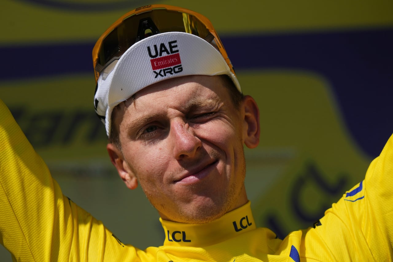Slovenia's Tadej Pogacar, wearing the overall leader's yellow jersey, celebrates on the podium after the ninth stage of the Tour de France cycling race over 174.1 kilometers (108 miles) with start in Chinon and finish in Chateauroux, France, Sunday, July 13, 2025. (AP Photo/Thibault Camus)