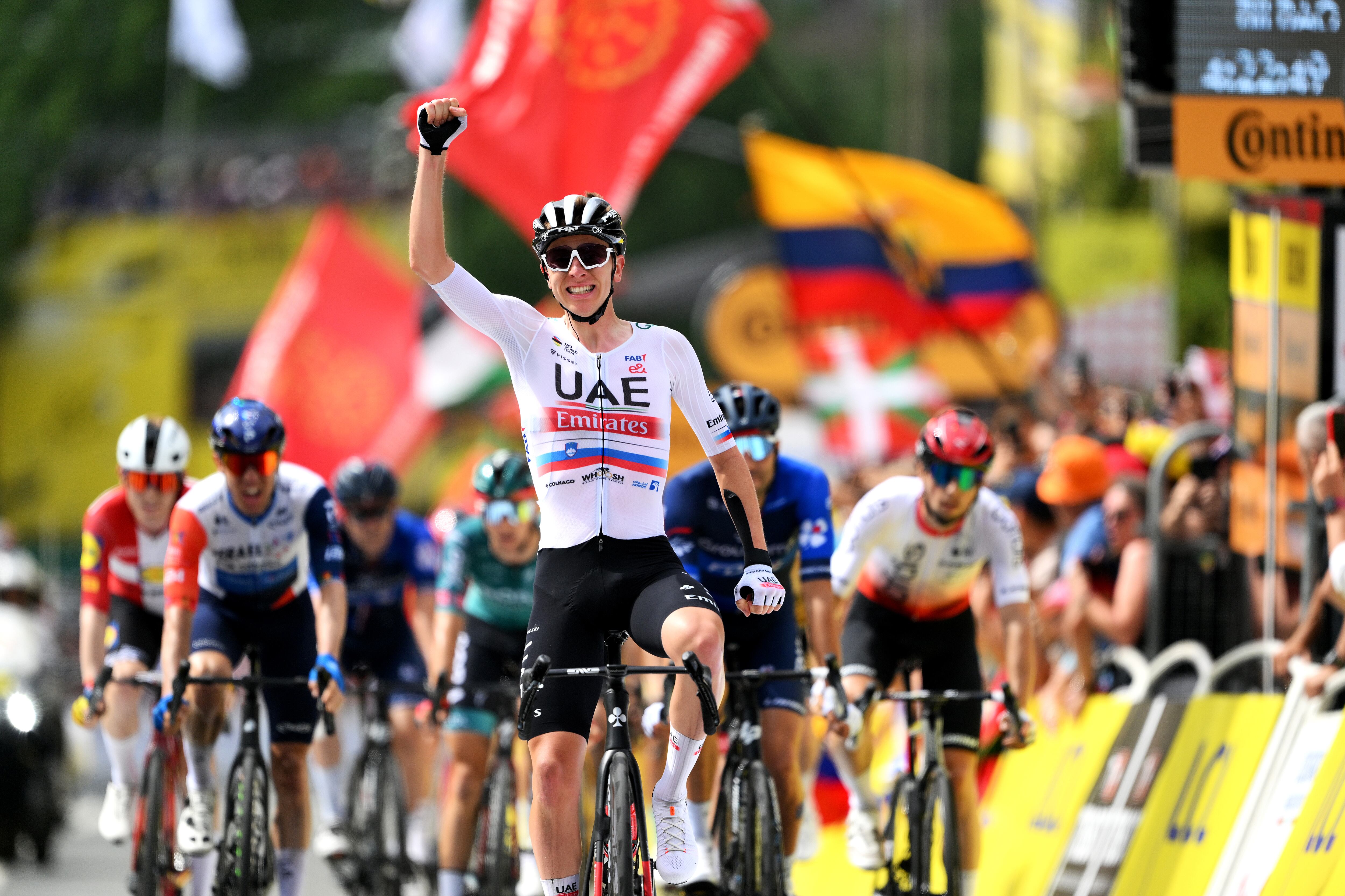 Tadej Pogacar celebrando la victoria de su compañero Yates en la primera etapa.