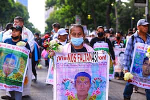 Manifestante sostiene una pancarta durante una manifestación para conmemorar el octavo aniversario de la desaparición de los estudiantes de Ayotzinapa el 26 de septiembre de 2022 en la Ciudad de México, México. El 26 de septiembre de 2014, 43 estudiantes de la Escuela Rural Isidro Burgos de Ayotzinapa desaparecieron en la ciudad de Iguala tras enfrentamientos con fuerzas policiales. Los estudiantes fueron acusados de intentar el secuestro de autobuses para ser utilizados en protestas. (Foto de Manuel Velásquez/Getty Images)