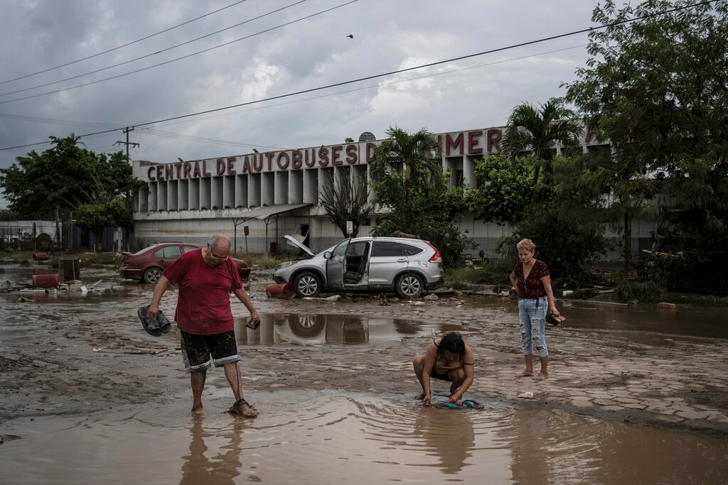 Vecinos caminan frente a la estación de autobuses dañada tras las fuertes lluvias en Poza Rica, Veracruz, México, el sábado 11 de octubre de 2025. (Foto AP/Felix Marquez)