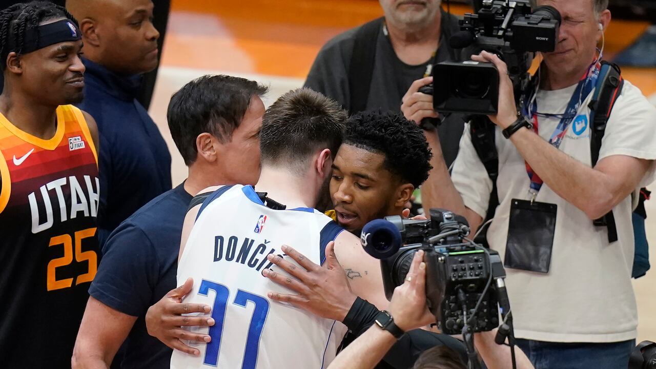 Dallas Mavericks guard Luka Doncic (77) and Utah Jazz guard Donovan Mitchell, rear, hug following Game 6 of an NBA basketball first-round playoff series Thursday, April 28, 2022, in Salt Lake City. (AP Photo/Rick Bowmer)