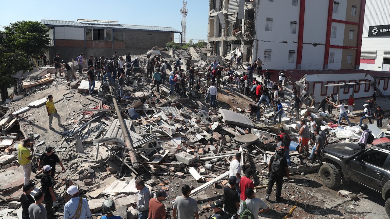 Residentes y rescatistas buscan entre los escombros de un edificio derrumbado tras el terremoto que sacudió Cali.