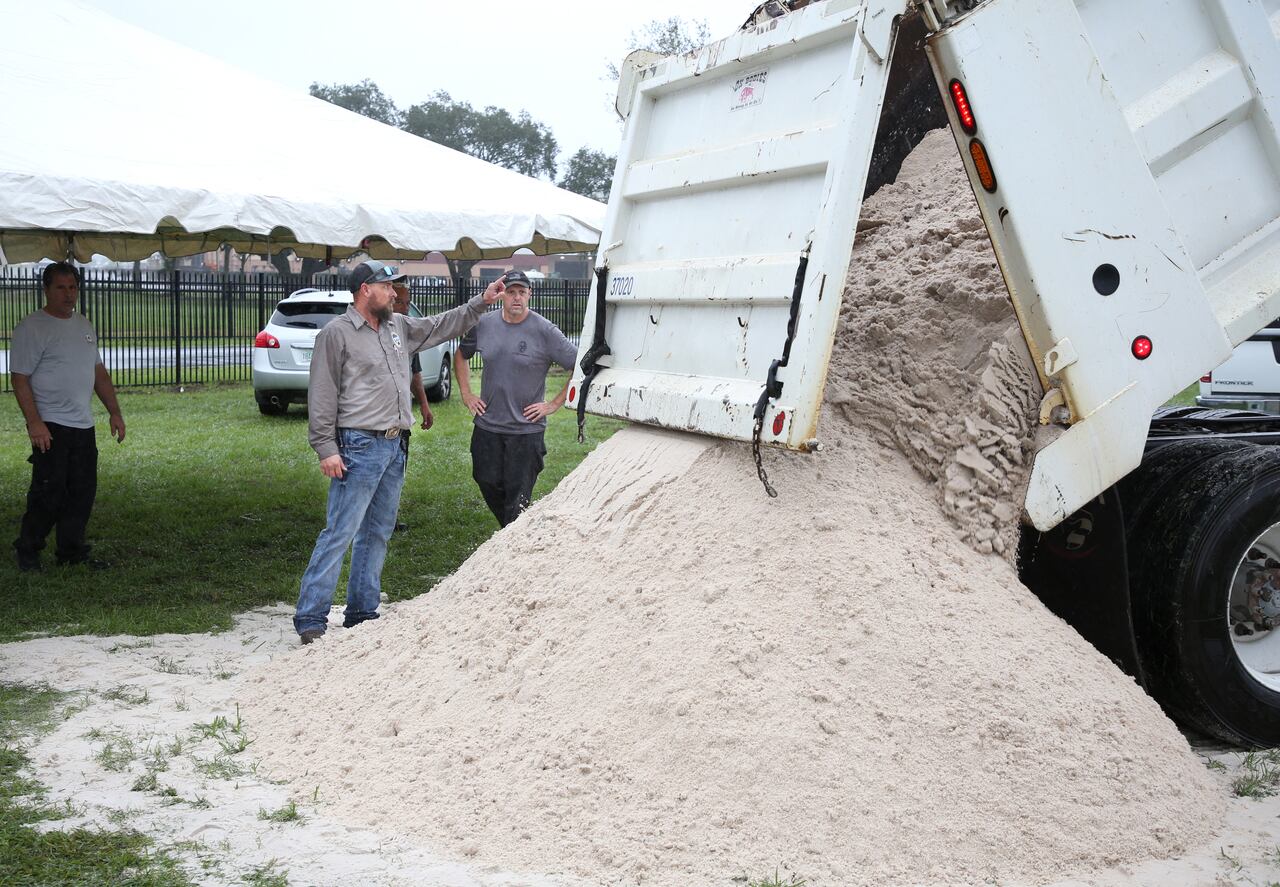Ciudadanos en la Florida ponen bolsas de arena para apaciguar lluvias ante la amenaza del huracán Milton.