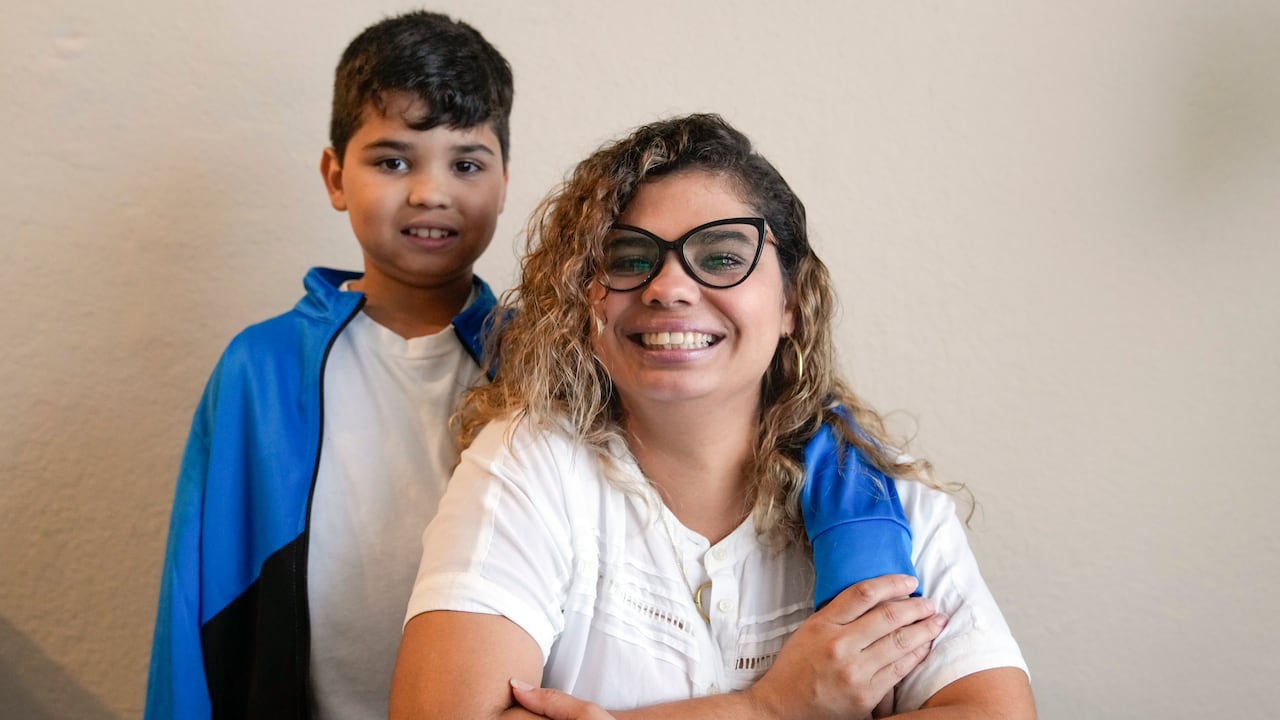 Caren Añez posa con su hijo Lucas Tello, de 10 años, en su apartamento de Orlando, Florida, el miércoles 27 de septiembre de 2023. Añez y su familia de Venezuela están buscando la protección de un estatus de residencia legal temporal conocido como TPS, que les permitiría pedir permiso de trabajo y los protegería de una deportación. (AP Foto/John Raoux)