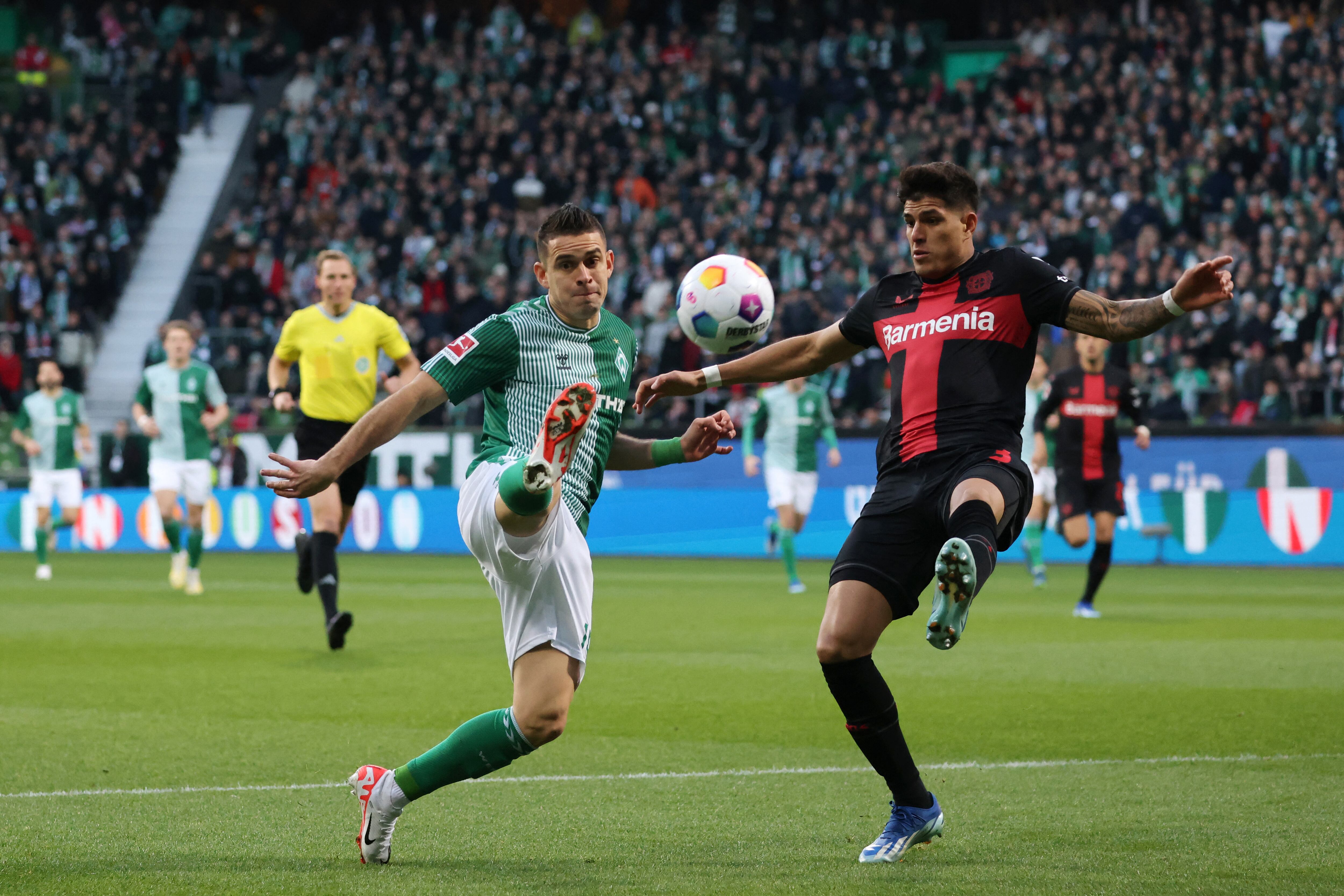 Rafael Borre (L) de Werder Bremen y el defensor ecuatoriano #03 de Bayer Leverkusen Piero Hincapie compiten por el balón durante el partido de fútbol de primera división de la Bundesliga alemana entre Werder Bremen y Bayer 04 Leverkusen en Bremen, Alemania, el 25 de noviembre de 2023. (Foto de Focke Strangmann / AFP)