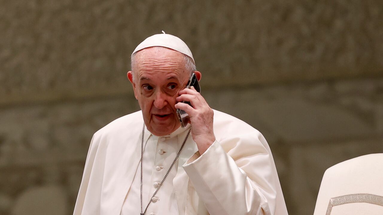 El Papa Francisco habla por un teléfono celular, que le dio su asistente Piergiorgio Zanetti, al final de su audiencia general semanal en la sala Pablo VI del Vaticano, el miércoles 11 de agosto de 2021 (AP Photo / Riccardo De Luca).