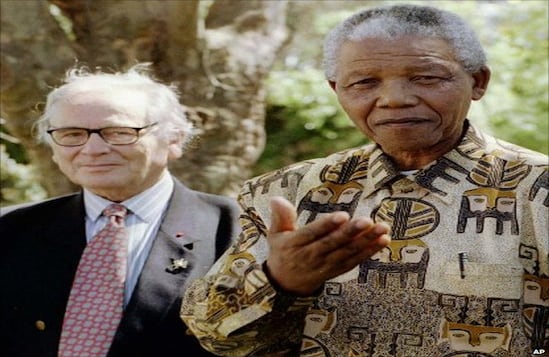 Mandela se transformó en un ícono por su estilo. Vestía camisas coloridas y brillantes. Esta imagen retrata el momento en el que el líder le preguntó a un grupo de periodistas qué opinaba de su camisa. Desde atrás lo observaba con atención el diseñador Pierre Cardin.