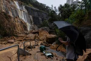 Un peatón toma fotografías de un deslizamiento de tierra tras fuertes tormentas en Hong Kong, el viernes, 8 de septiembre de 2023.