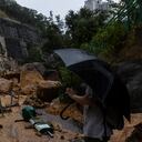 Un peatón toma fotografías de un deslizamiento de tierra tras fuertes tormentas en Hong Kong, el viernes, 8 de septiembre de 2023.