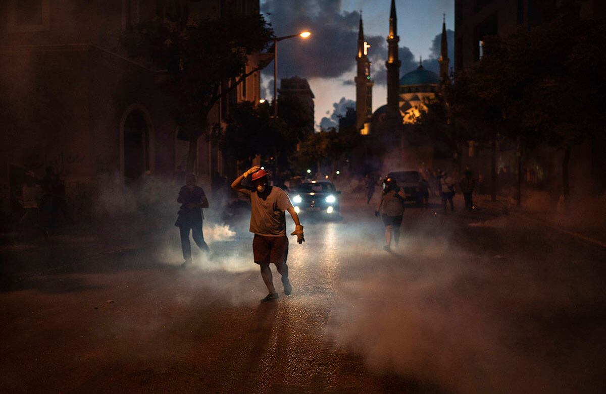 Los manifestantes huyen de los gases lacrimógenos disparados por la policía. AP Photo/Felipe Dana.