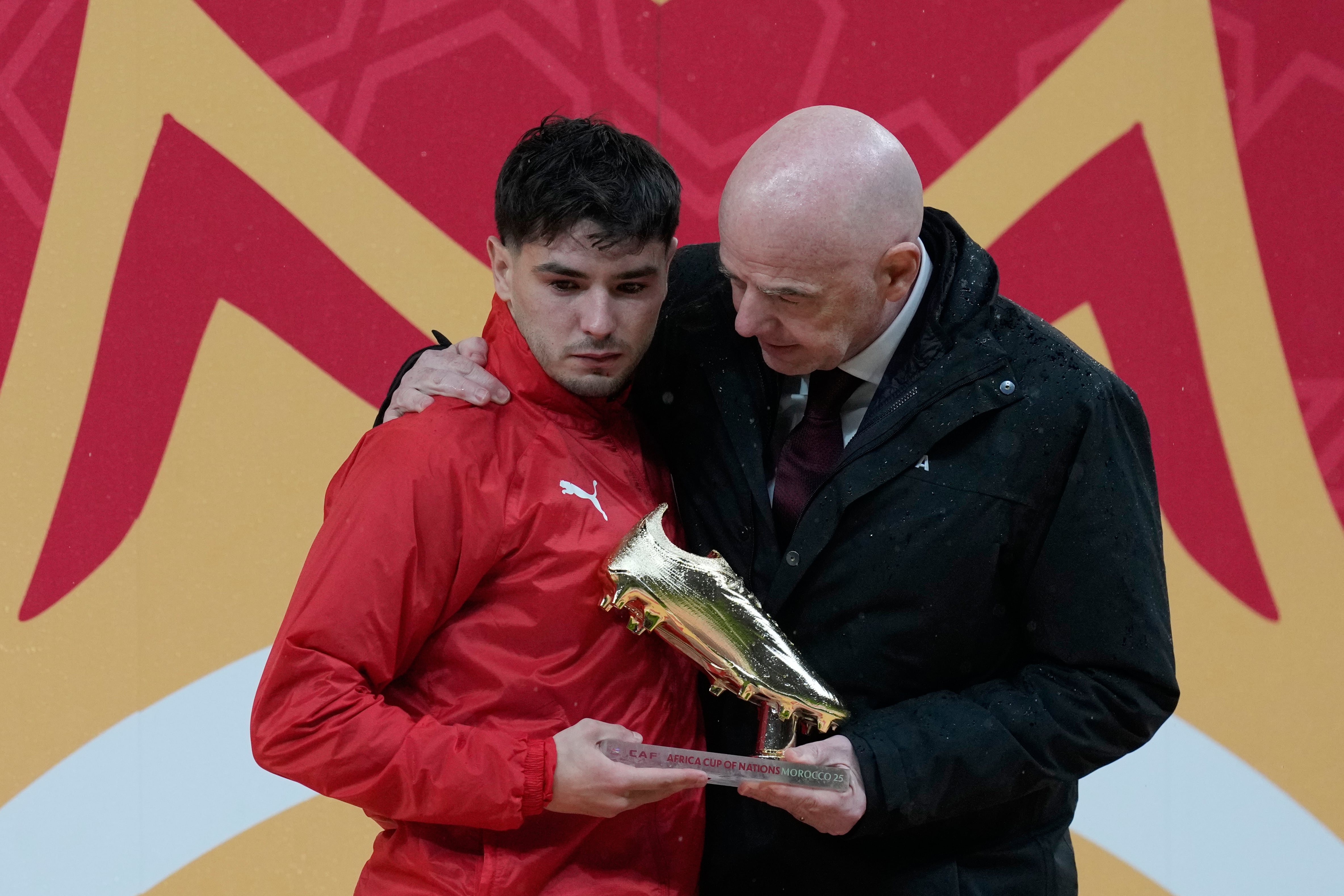 Morocco's Brahim Abdelkader Diaz, left, is embraced by FIFA President Gianni Infantino after reaching the golden boot after the Africa Cup of Nations final soccer match between Senegal and Morocco in Rabat, Morocco, Sunday, Jan. 18, 2026. (AP Photo/Themba Hadebe)