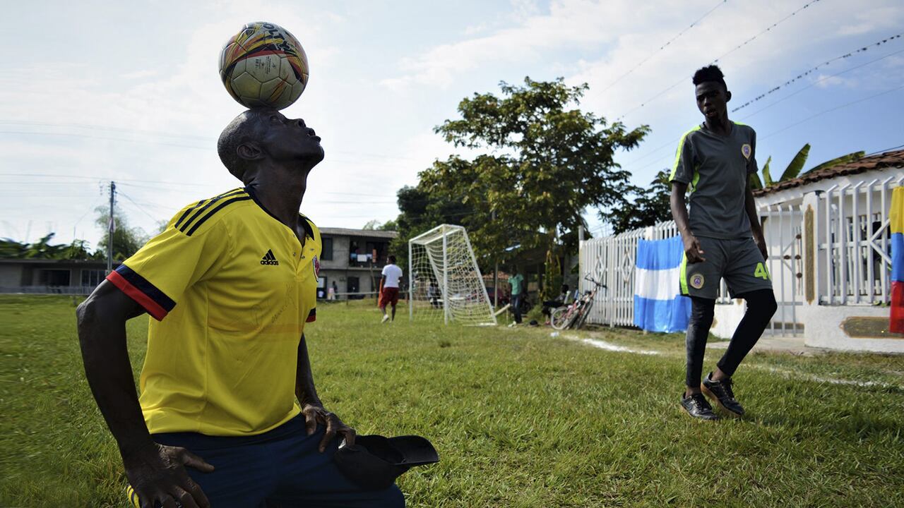 Aristarco “Paco” Mina domina el balón con su cabeza sobre la cancha principal de Ciénaga Honda, un corregimiento de Guachené, norte del Cauca, mientras uno de los jugadores de la categoría juvenil de la fundación se nota sorprendido por su habilidad.