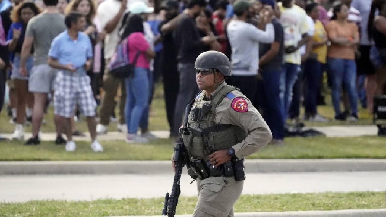 Un oficial de la ley camina mientras las personas son evacuadas de un centro comercial donde ocurrió un tiroteo el sábado 6 de mayo de 2023 en Allen, Texas.